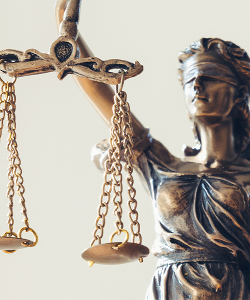 A statue of Lady Justice, blindfolded, holding balanced scales, symbolizing fairness and impartiality in the law.